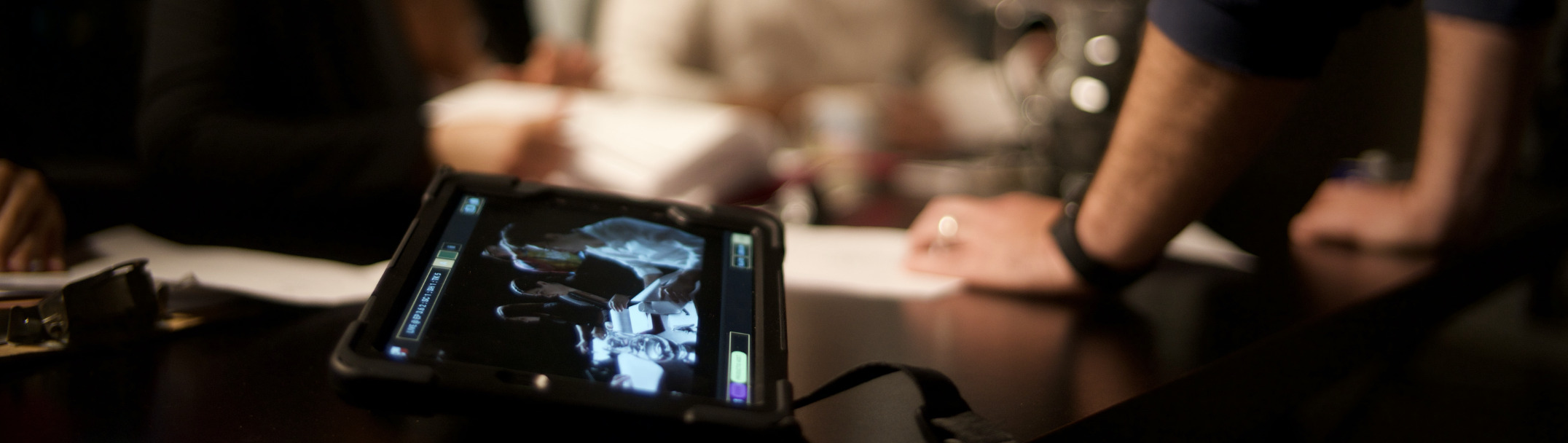 An Onset tablet laying on a desk and crew working in the background